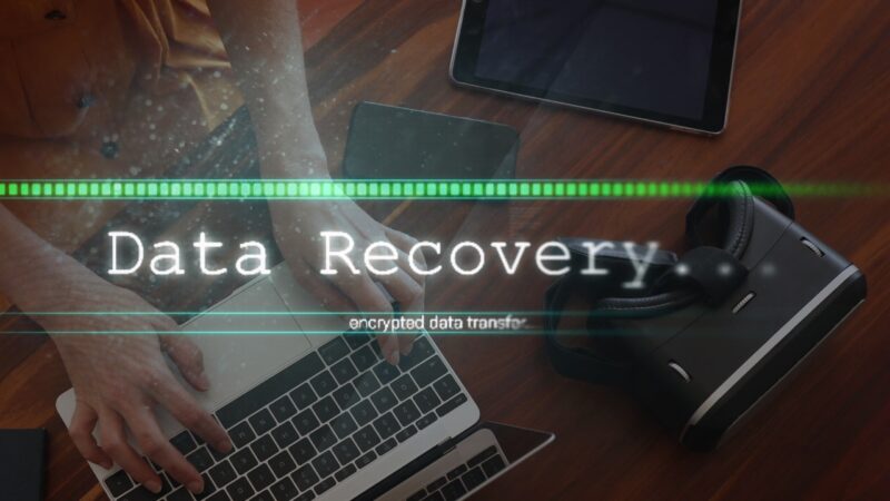 Person using a laptop with a data recovery screen overlay