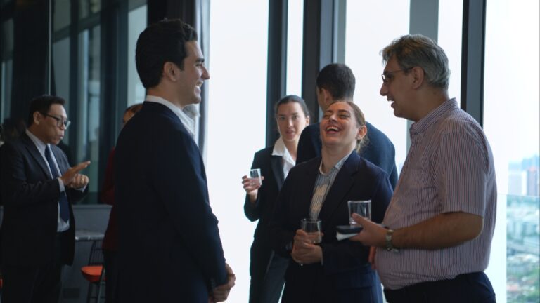 Business professionals talk at a private executive event in a modern high-rise venue