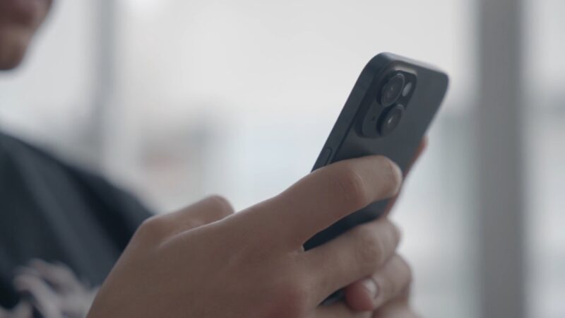 A person uses a smartphone near a window
