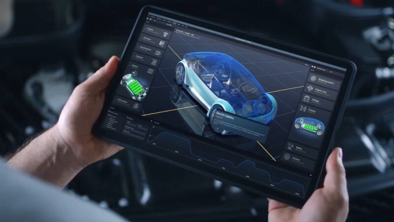 A technician views an electric car systems dashboard on a tablet