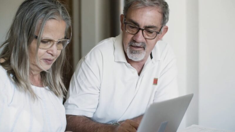 An older couple reviews Lifeline account details on a laptop