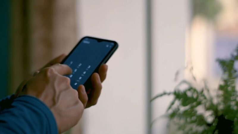A person uses a smartphone near a window