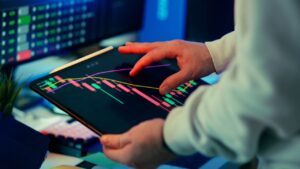 Person reviews crypto market charts on a tablet