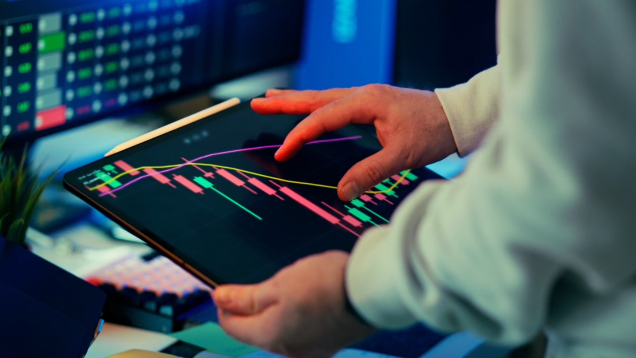 Person reviews crypto market charts on a tablet