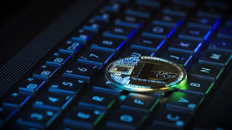 Crypto coin rests on a backlit laptop keyboard