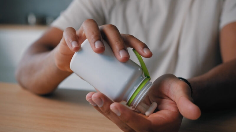 Person pours magnesium capsules into one hand