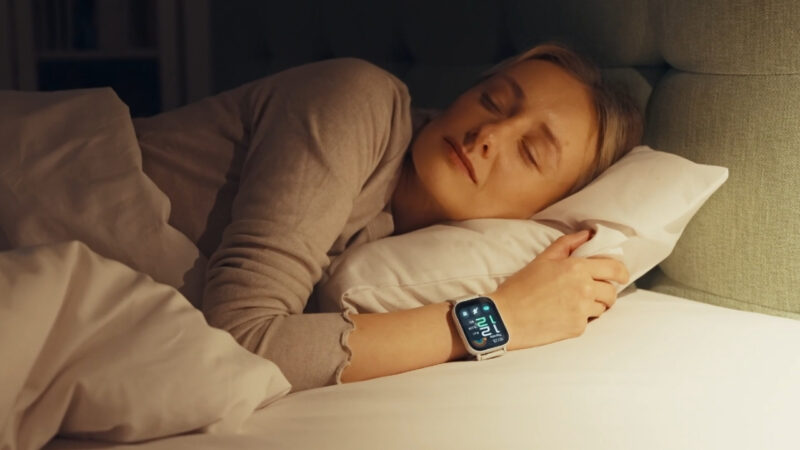 Woman sleeps in bed with a smartwatch on her wrist
