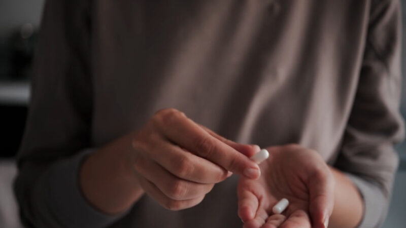 Person holds two magnesium capsules in their hands