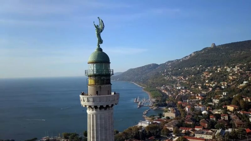 Coastal lighthouse above a hillside town on the Adriatic coast of Italy.