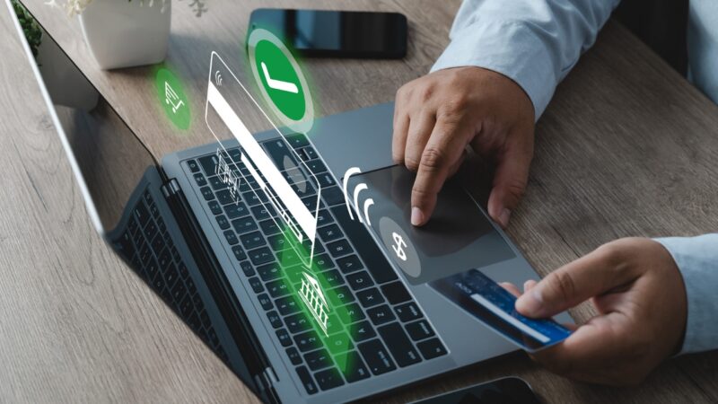 A person makes an online card payment on a laptop.