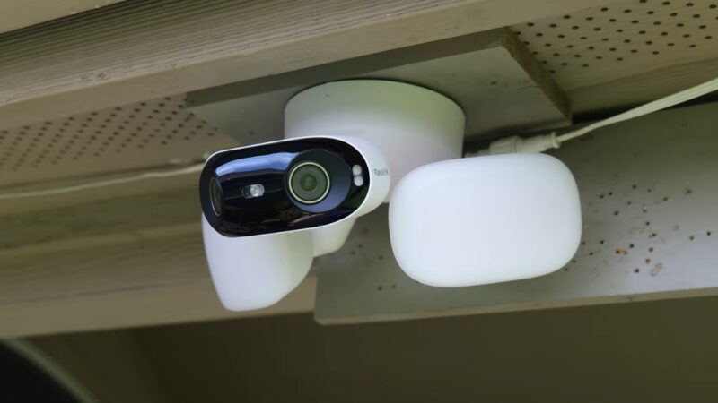 Outdoor security camera mounted under a home roof.